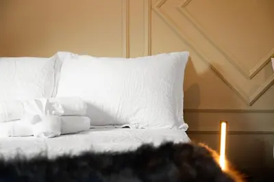 a white bed with a pile of pillows and a candle at Pocono Summit Lodge Game Room & Family Fun in Pocono Summit