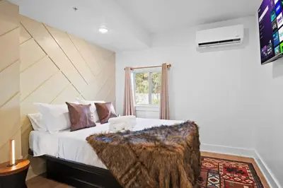 a bedroom with a large bed with a wooden headboard at The Grand Pocono Getaway Waterparks & Raceway in Pocono Summit