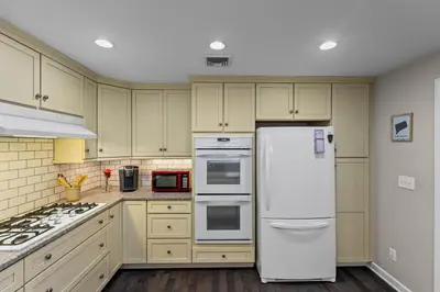 a kitchen with a white refrigerator and a stove at New England Nest - Modern 2BR Home with EV Charger in Shelton