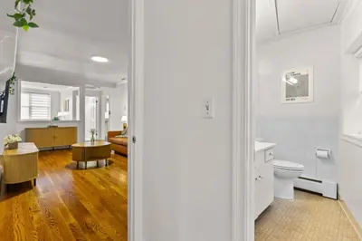 a white bathroom with a toilet and a sink at New England Nest - Modern 2BR Home with EV Charger in Shelton