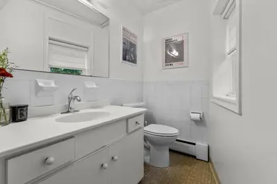 a white bathroom with a toilet and a sink at New England Nest - Modern 2BR Home with EV Charger in Shelton