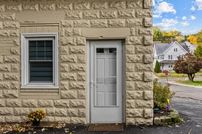 a white door and two windows on a building at New England Nest - Modern 2BR Home with EV Charger in Shelton