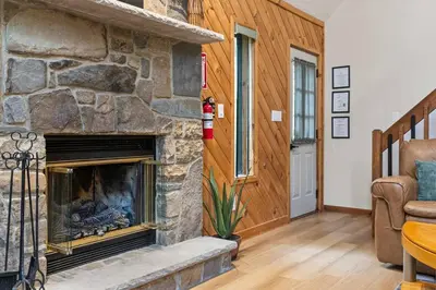 a stone fireplace in a living room with a couch at Pocono's Resort | Fire Pit, Jacuzzi, Winter Sport in Lake Ariel