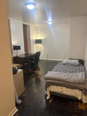 a bedroom with a bed and a desk and a table at Inner City Charm in New York