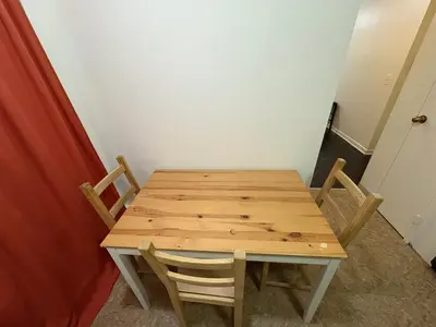 a wooden table and chairs in a room at Inner City Charm in New York