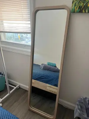 a mirror in a bedroom with a bed in it at Cozy guest room 20mins to city in North Bergen