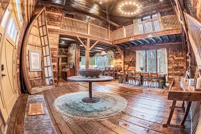 a room with a table in the middle of a building at Modern Barn with Hot Tub, Game Room & Sleeps 14 in High Falls