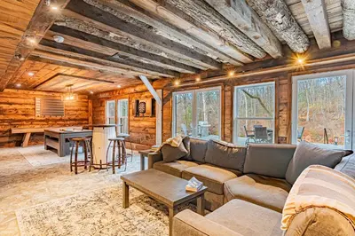 a living room with a couch and a table at Modern Barn with Hot Tub, Game Room & Sleeps 14 in High Falls
