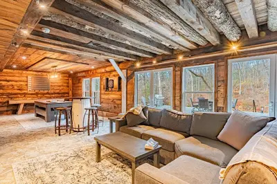 a living room with a couch and a table at Modern Barn with Hot Tub, Game Room & Sleeps 14 in High Falls