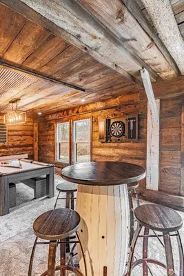 a room with a ping pong table and some stools at Modern Barn with Hot Tub, Game Room & Sleeps 14 in High Falls