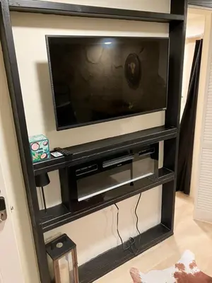 a black entertainment center with a flat screen tv at Comfort guest room near everything in Guttenberg