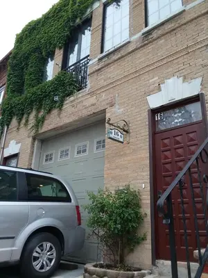 a car parked in front of a building with a garage at 2 bedroom Loft in Old Fire house 35 min from manhattan in Jersey City