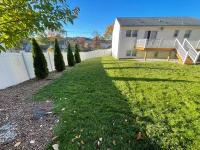 a yard with a fence and a house at Modern Glam Getaway 30 minutes from NYC in West Orange