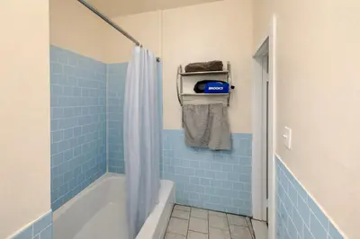 a bathroom with a tub and a shower with blue tiles at Bright & Modern Apartment Near Subway & Columbia in New York