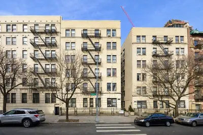 a large building with cars parked in front of it at Bright & Modern Apartment Near Subway & Columbia in New York