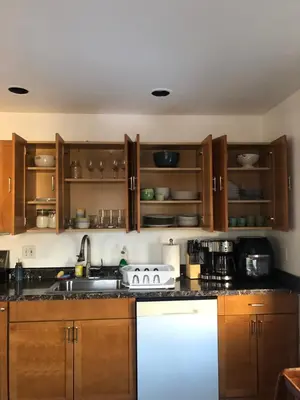 a kitchen with wooden cabinets and a sink at Comfort house with two bed room in Greenwich