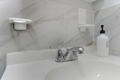a bathroom sink with a soap bottle next to it at Cozy 2BR Apartment in Jersey City with Smart Lock in Croxton