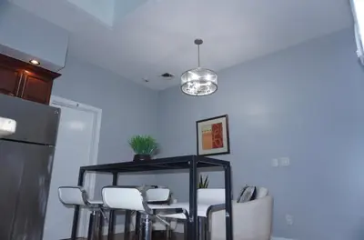 a dining room with a table and white chairs at New York Private Room 32 in West New York