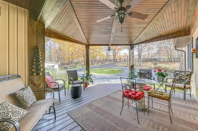 a screened porch with a ceiling fan and chairs at Beautiful and Unique Farmhouse 15 Mi to Saratoga in Argyle