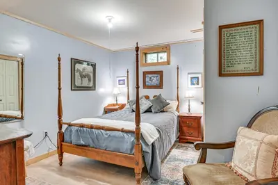 a bedroom with a bed and a chair at Beautiful and Unique Farmhouse 15 Mi to Saratoga in Argyle