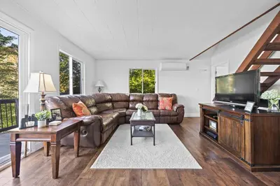 a living room with a couch and a flat screen tv at Cozy Mountain Retreat 3 Min to Hunter Mountain in Hunter