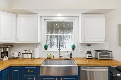 a kitchen with blue cabinets and a sink and a window at The Waters Edge Escape in East Stroudsburg