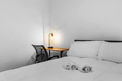 a dog laying on top of a white bed at 3BR Apt Mins to Bus Newark Airport Penn Sta NYC in Hillside