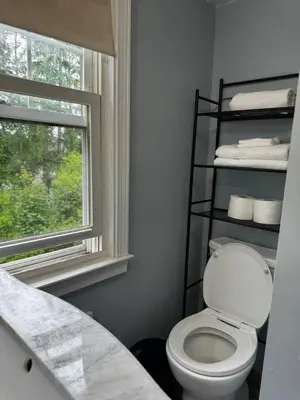 a bathroom with a toilet and a window at Pet Friendly 3BR New Britain Home with King Bed Near Hartford Sleeps 8 in New Britain