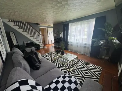 a living room with a couch and a stair case at Pet Friendly 3BR New Britain Home with King Bed Near Hartford Sleeps 8 in New Britain