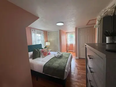 a bedroom with a bed with a green blanket at Pet Friendly 3BR New Britain Home with King Bed Near Hartford Sleeps 8 in New Britain