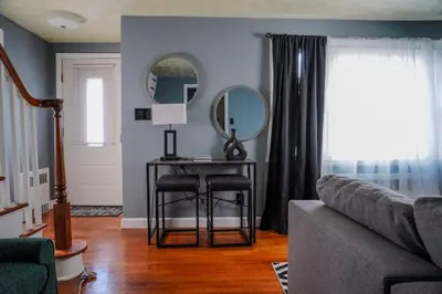 a living room with a table with two chairs and a mirror at Pet Friendly 3BR New Britain Home with King Bed Near Hartford Sleeps 8 in New Britain