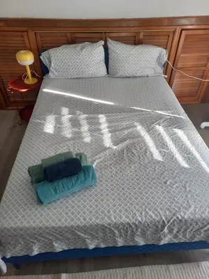 a bed with two towels sitting on top of it at Cozy attic guest room in North Bergen