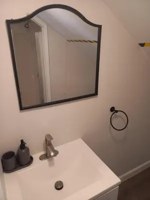 a bathroom with a sink and a mirror on the wall at Cozy attic guest room in North Bergen