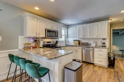 a kitchen with white cabinets and green bar stools at Family Retreat with Game Room, 4 Mi to Kalahari! in Emerald Lakes