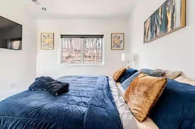a bedroom with a blue bed and a window at Modern Lakeview Home with Private Dock Sleeps 5 in Landing