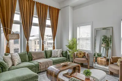 a living room with a green couch and a table at 6 Mi to Manhattan Luxe Apt with City Views! in Jersey City