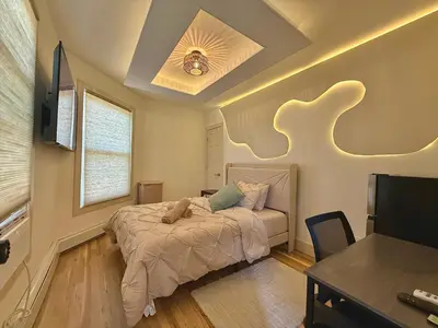 a bedroom with a bed and a desk and a tv at Spring Rooms by Yale & Downtown in New Haven