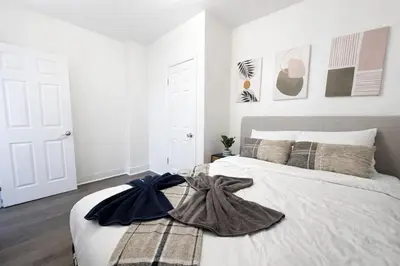 a bedroom with a bed with a blanket on it at Spacious 3BR NYC Manhattan Skyline Views Nearby in West New York
