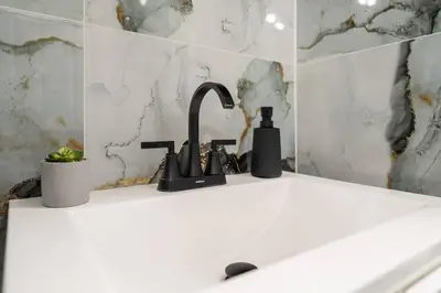 a kitchen sink with a black faucet at Spacious 3BR NYC Manhattan Skyline Views Nearby in West New York