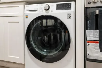 a white washing machine sitting next to two other machines at Fast access to NYC - family & group -skyline view in Jersey City