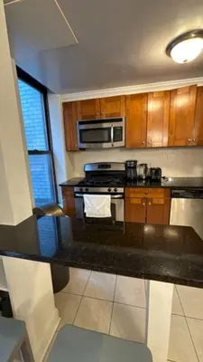 a kitchen with a stove and a microwave at Trendy 5-Bedroom Home in NYC Prime Location in New York