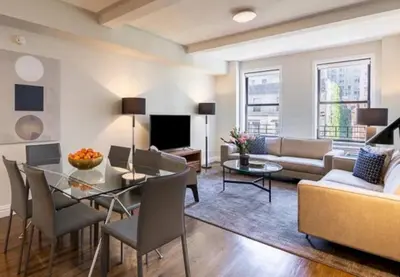 a living room with a table and a couch at Spacious 3 Bed 3 Bath Unit in Upper East Side in New York