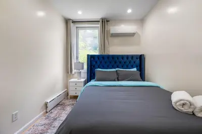 a bedroom with a blue bed and a window at Spacious 3 Bed 3 Bath Unit in Upper East Side in New York