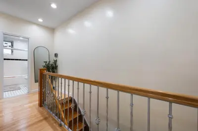 a staircase in a home with white walls and wood floors at Spacious 3 Bed 3 Bath Unit in Upper East Side in New York