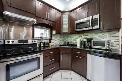 a large kitchen with wooden cabinets and appliances at Spacious 3 Bed 3 Bath Unit in Upper East Side in New York