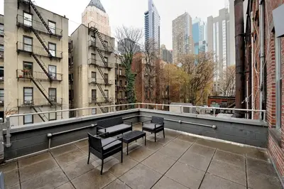 a balcony with benches and tables in a city at Time Square Vicinity- Luxury 2BR 2BA NYC Apt in New York