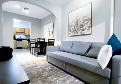 a living room with a couch and a kitchen at Spacious Stay 3 BR in Prime Location of NYC in New York