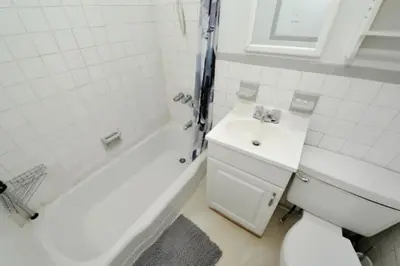 a bathroom with a sink and a toilet and a bath tub at Spacious Stay 3 BR in Prime Location of NYC in New York