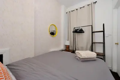 a bedroom with a bed and a mirror on the wall at Spacious Stay 3 BR in Prime Location of NYC in New York
