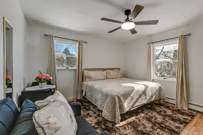 a living room with a couch and a bed at Easy Transit to NYC! Sleek North Shore Hideaway in Huntington Station